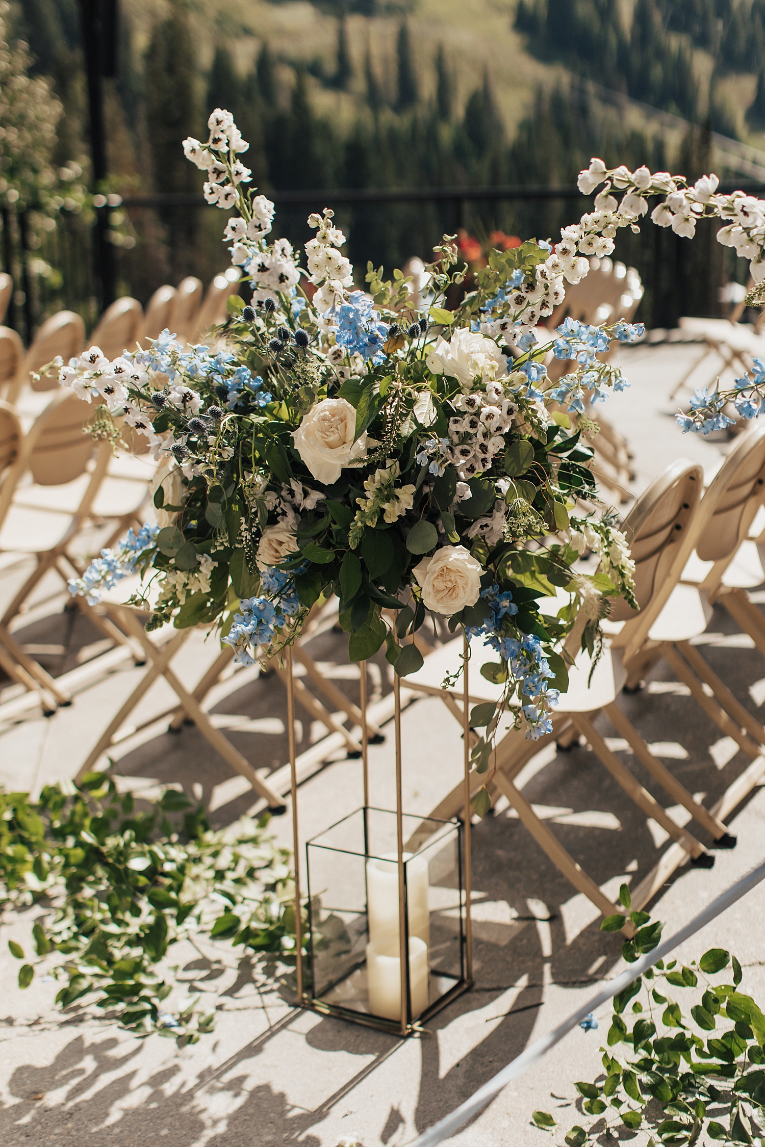 large bouquet of blue and white flowers next to aisle by Destination wedding photographer