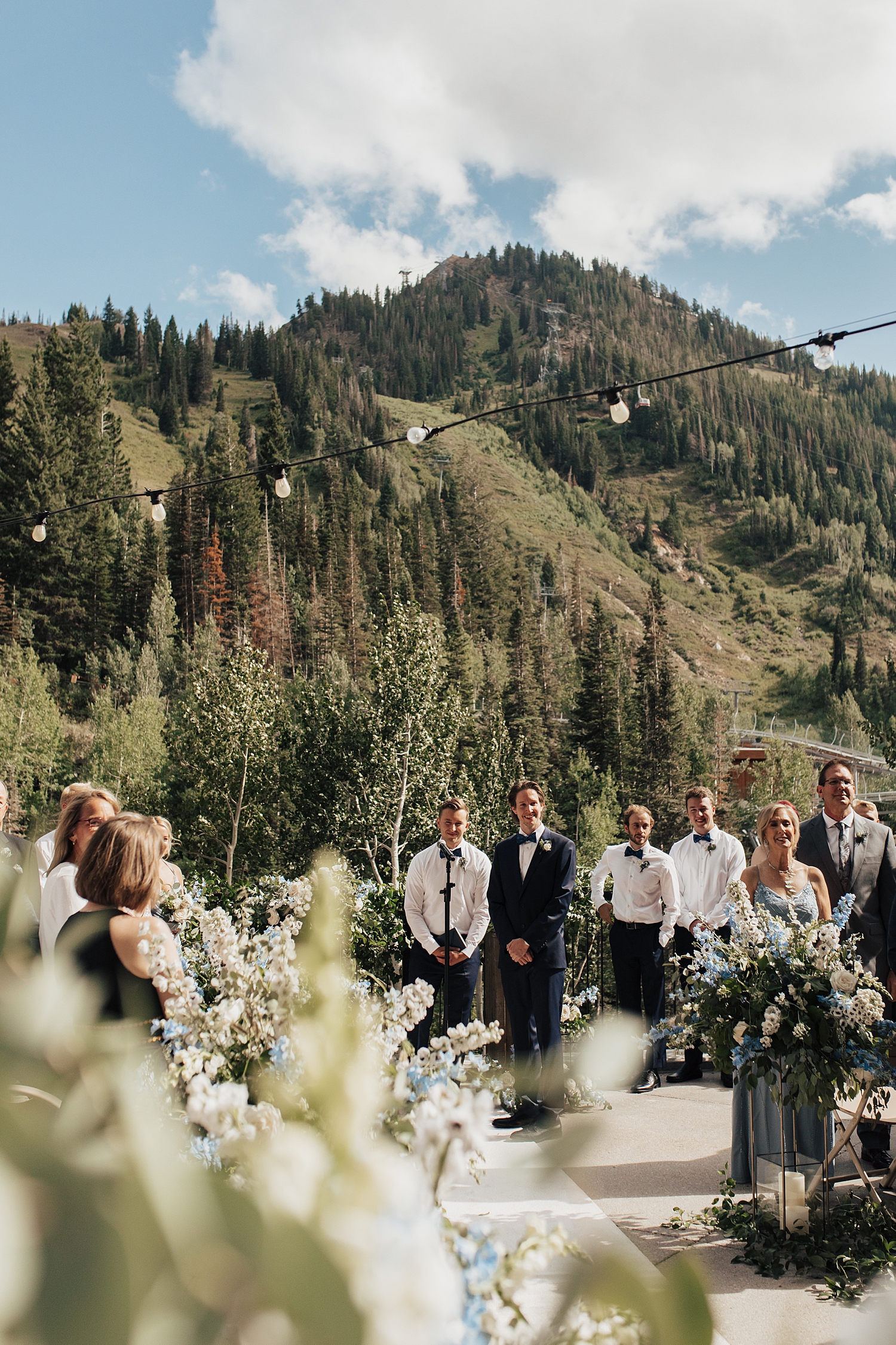 groom watches bride walk down outdoor aisle by Nicole Aston Photography