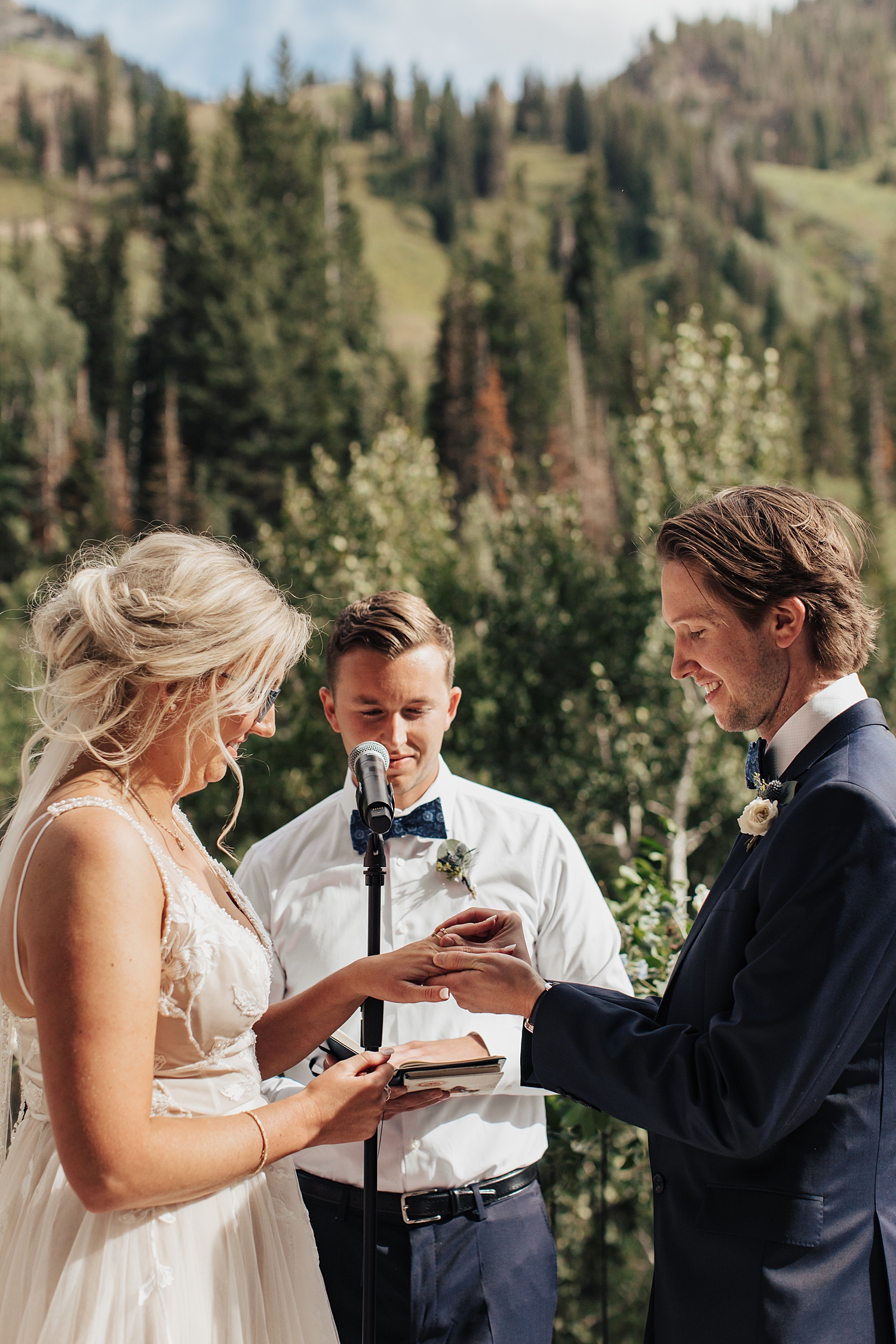 officiant prompts couple to exchange rings during ceremony at Snowbird Mountain
