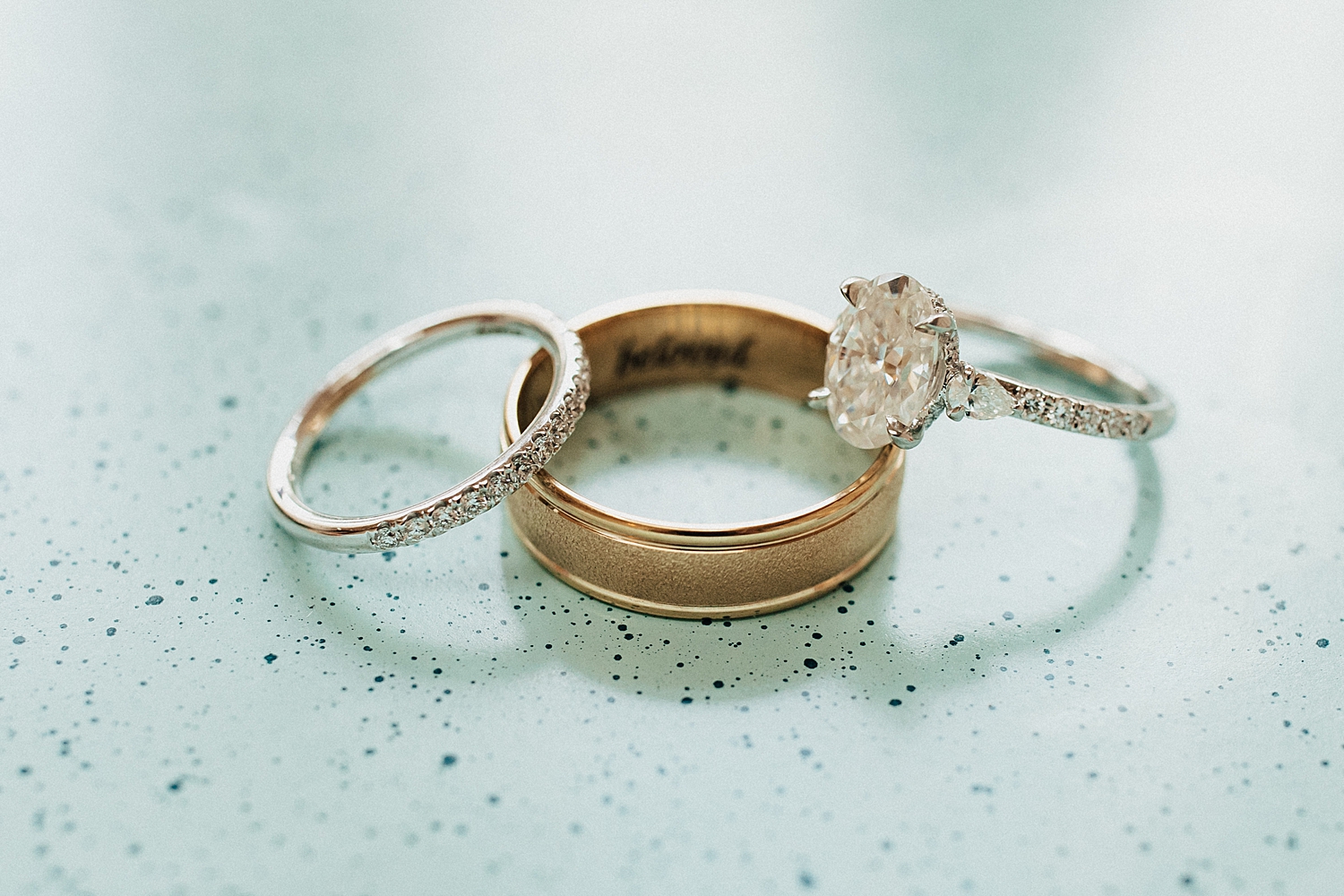 three rings stacked on blue backdrop by Nicole Aston photography