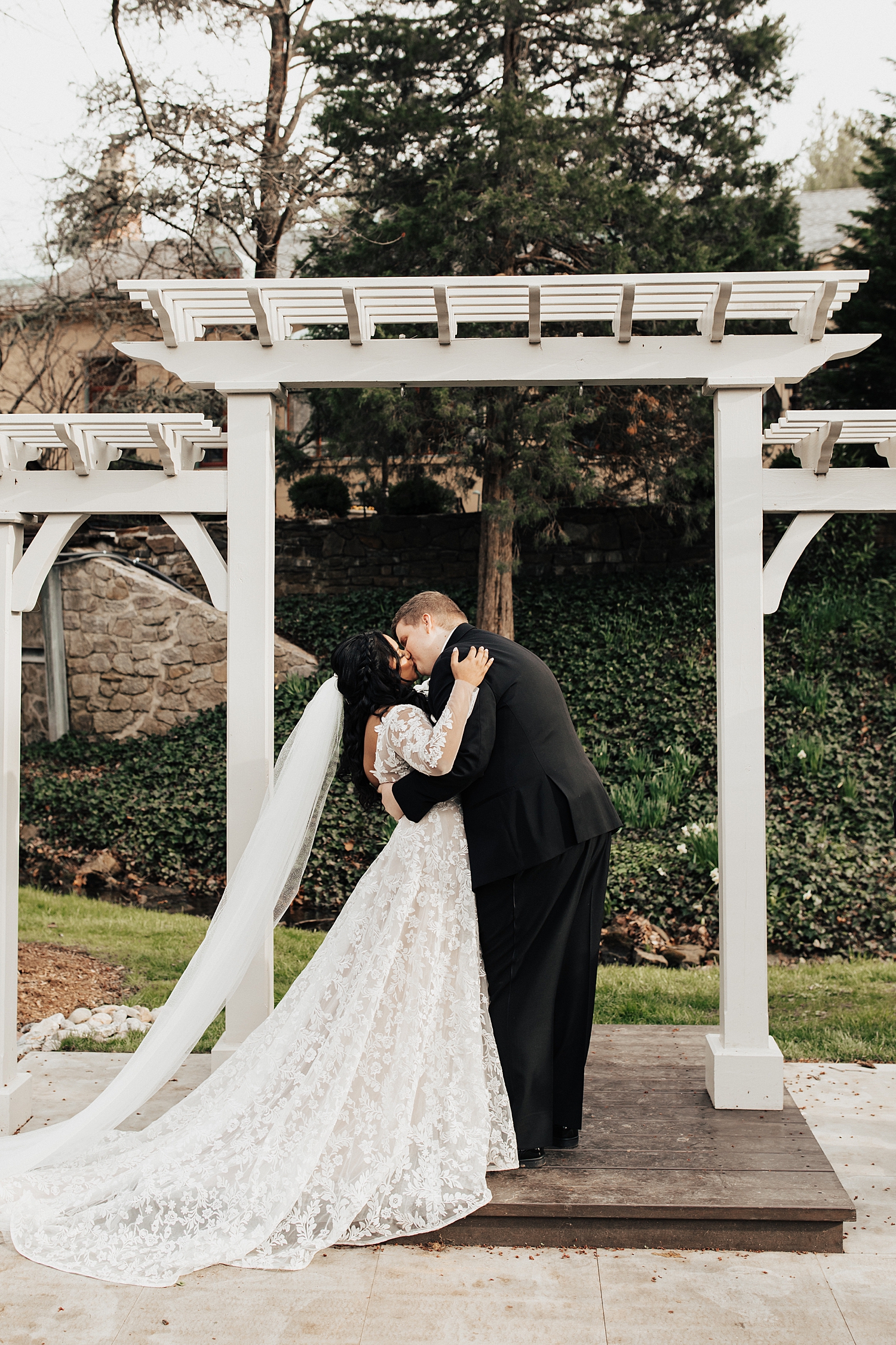 couple share a first kiss at alter by Nicole Aston photography