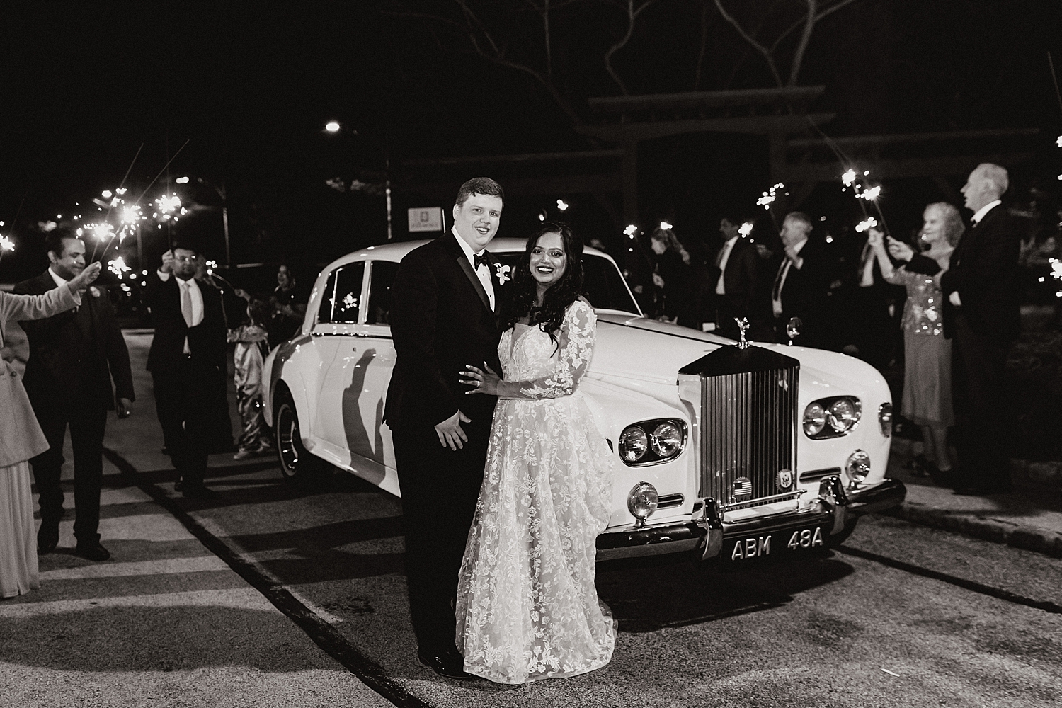 bride and groom stand in front of vintage car by Destination wedding photographer