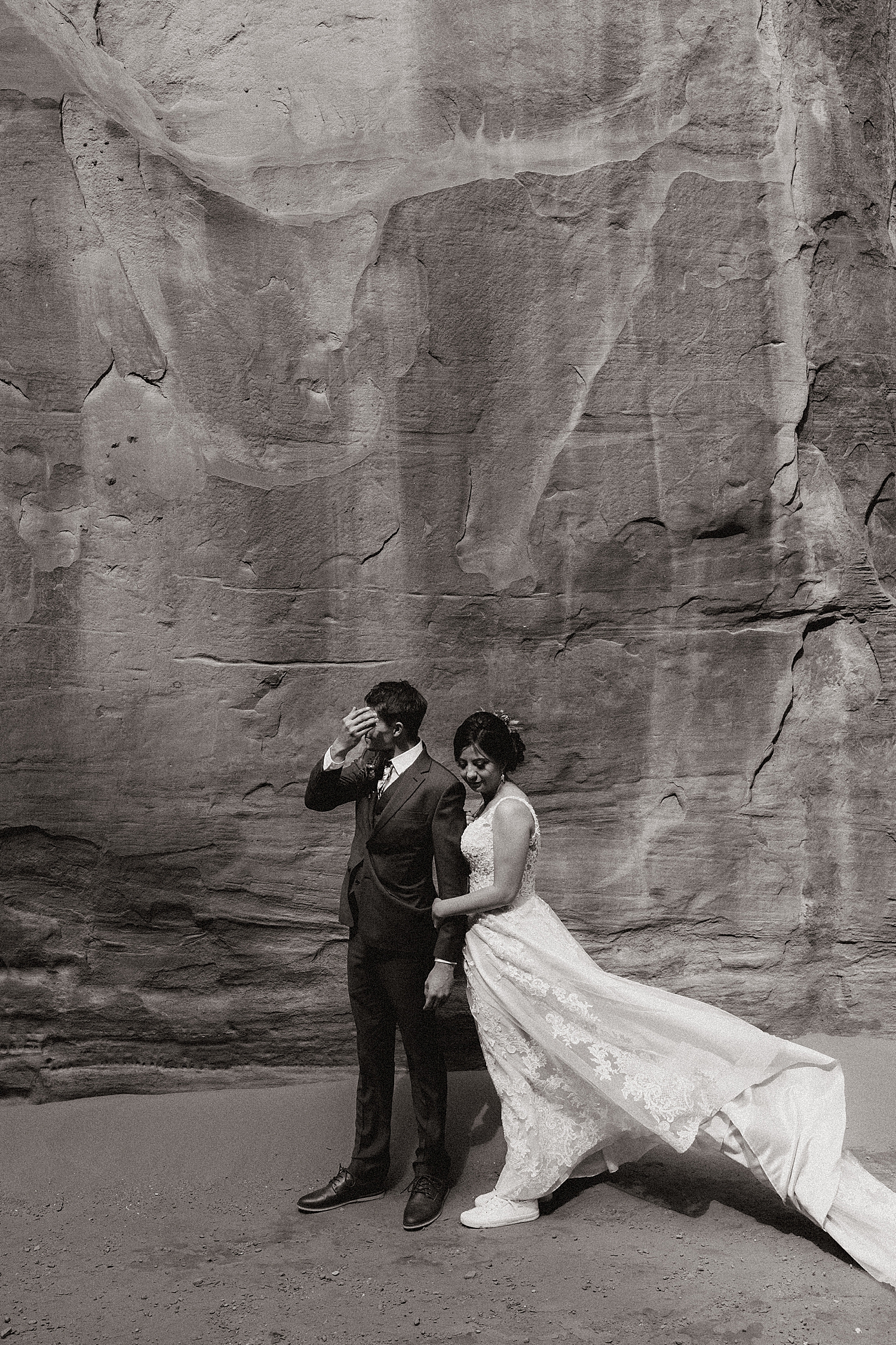 groom and bride stand in desert by Nicole Aston Photography