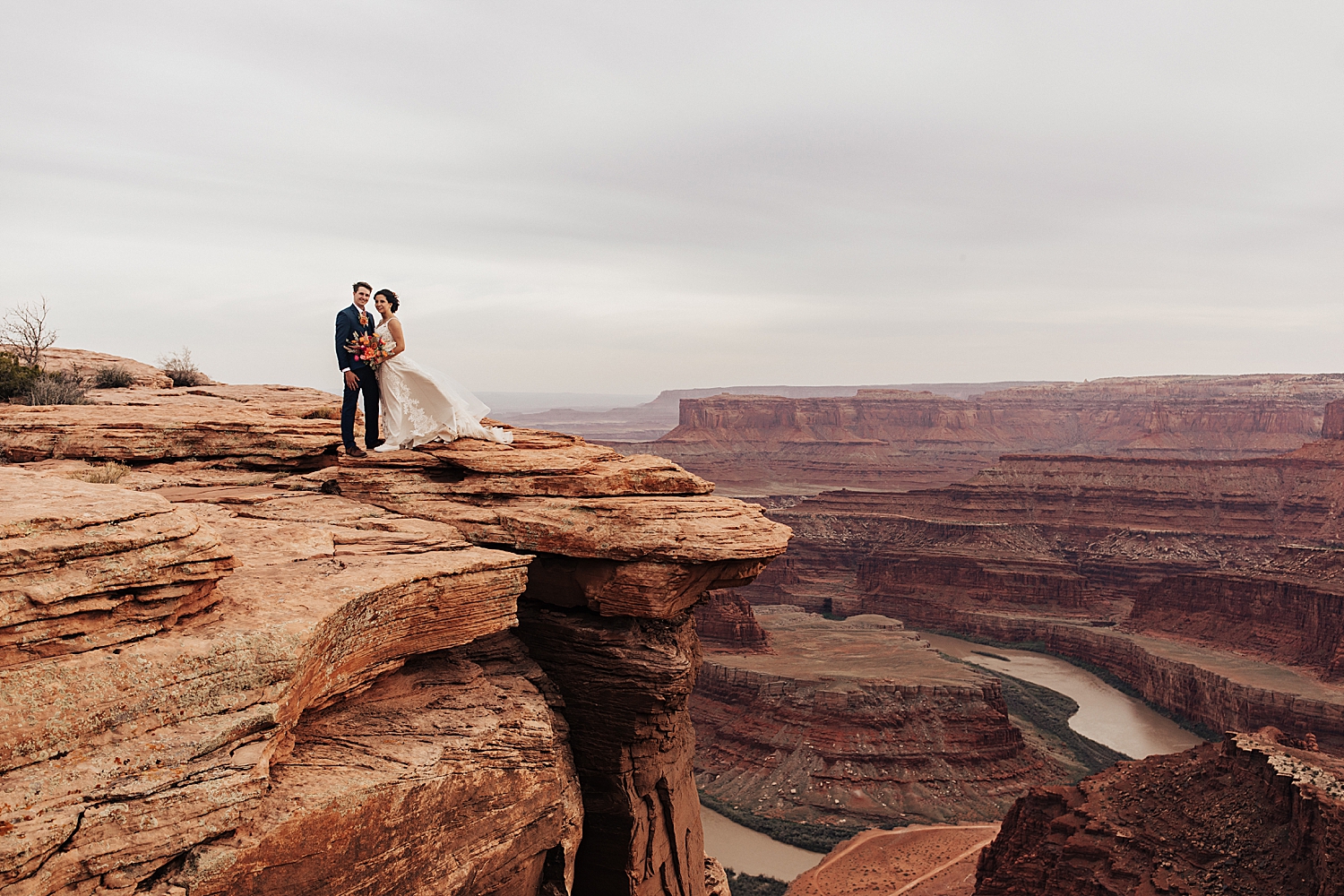 couple stand on dead horse point for portraits by Destination wedding photographer
