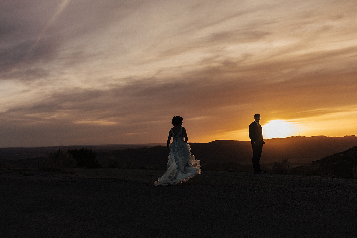 couple walk into the setting sunset in moab by Destination wedding photographer