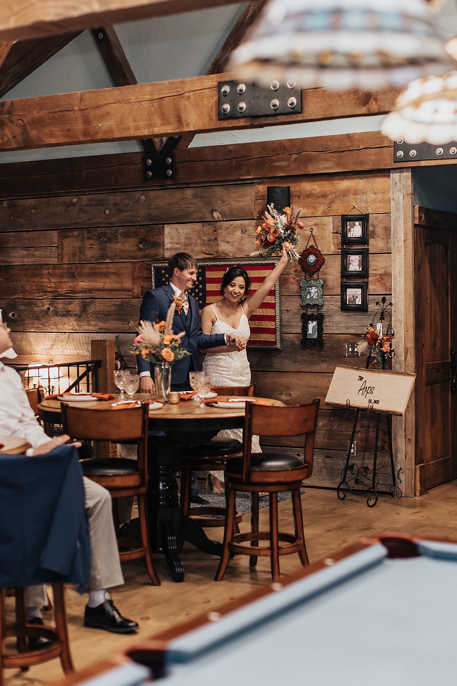 husband and wife walk into their reception happily by Nicole Aston Photography