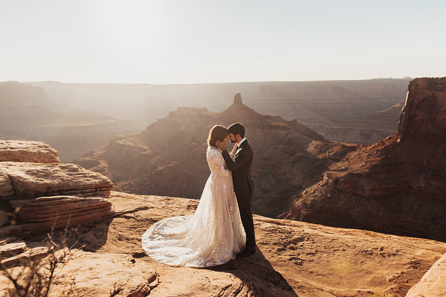 newlyweds embrace on edge of cliff for Full Moon Bridal Session