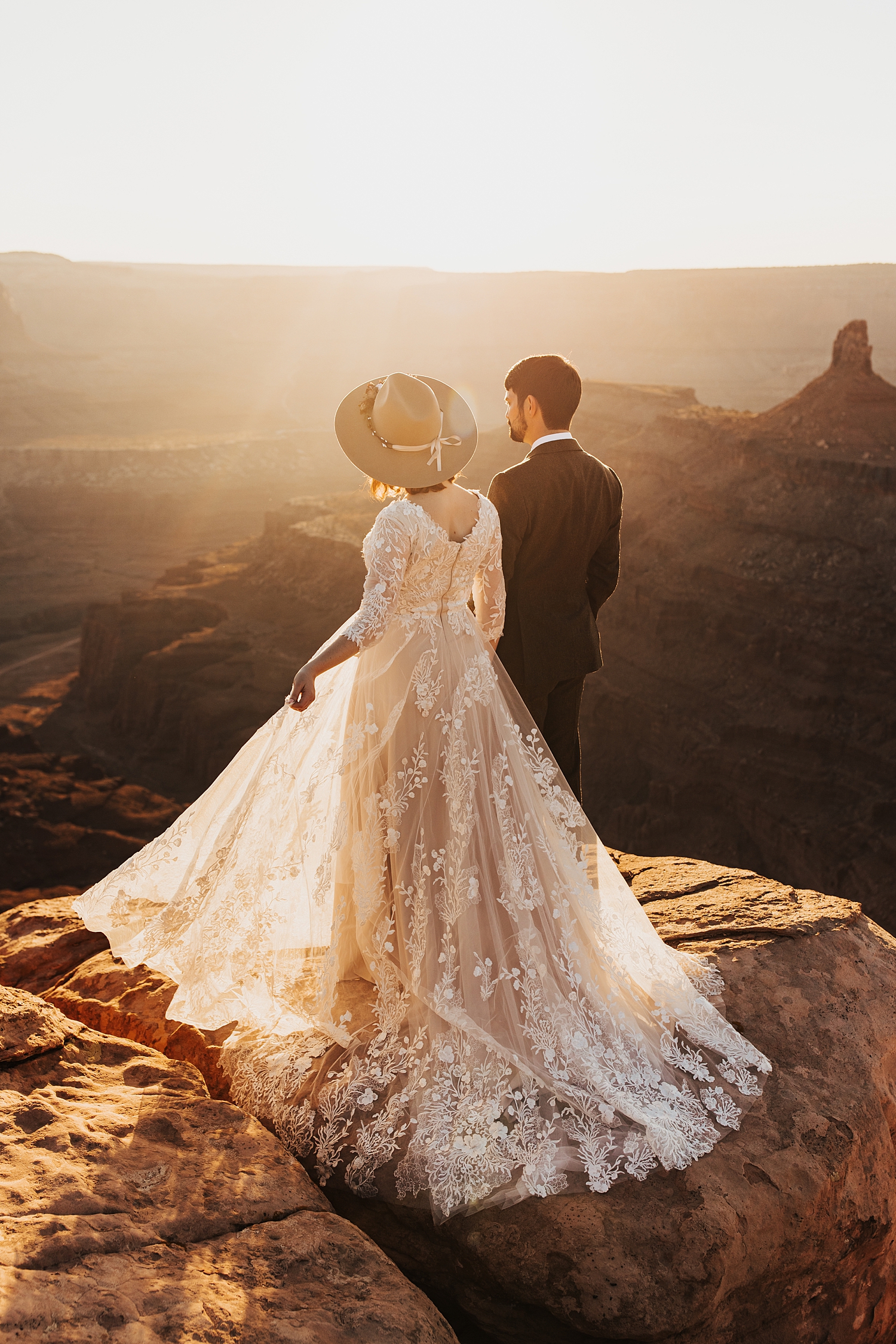 bride shows off her lace gown on cliffside for Full Moon Bridal Session