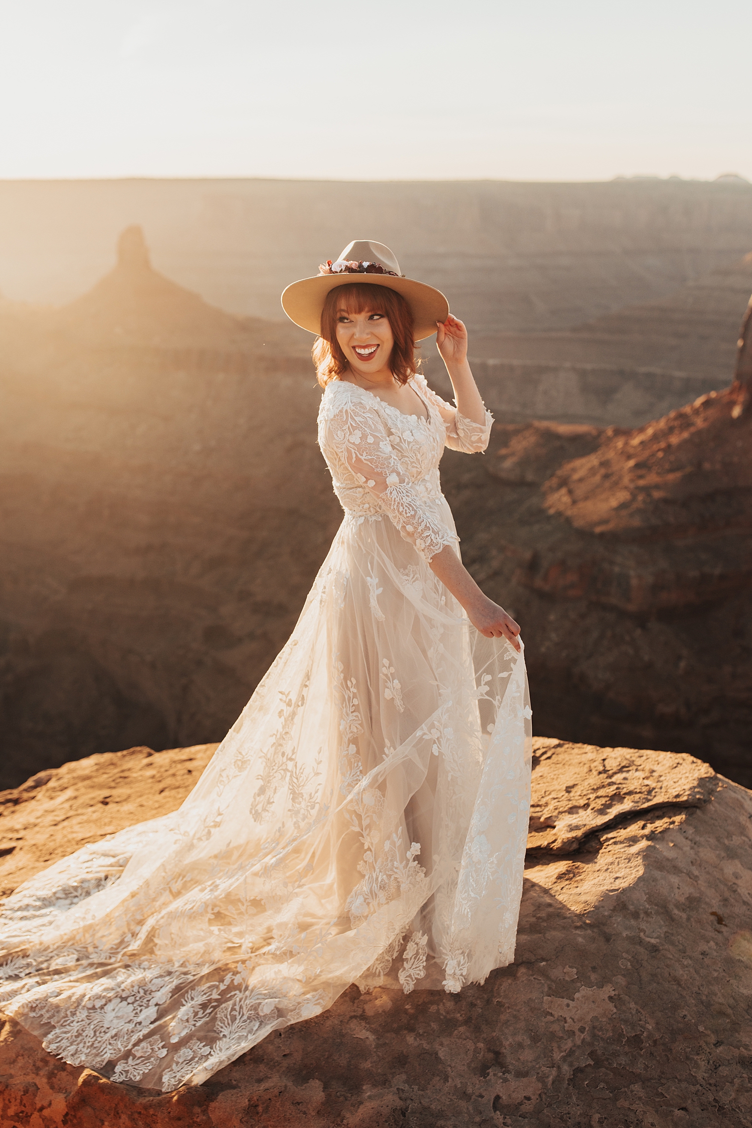 grinning bride spins her dress at Dead Horse point for Full Moon Bridal Session