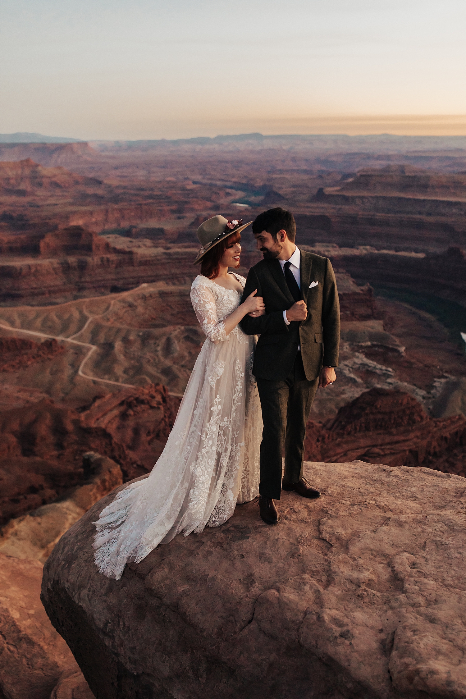 man and woman gaze at each other overlooking a canyon for Full Moon Bridal Session