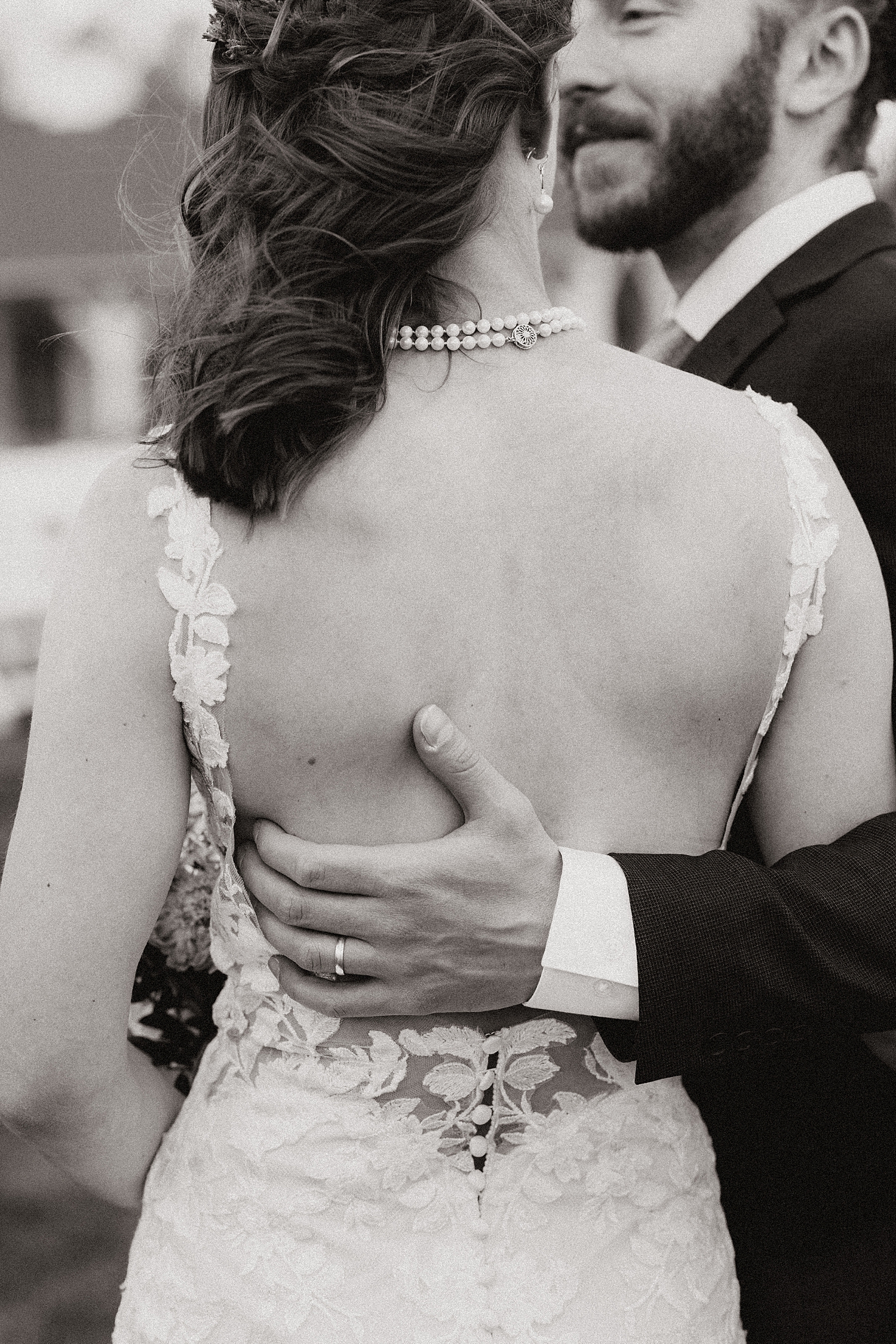 man wraps his arm around his bride to be by Nicole Aston photography