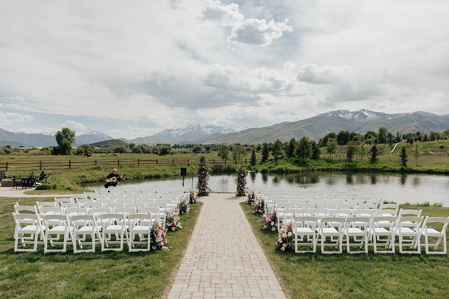 chairs set up on lawn in front of pond by Destination wedding photographer