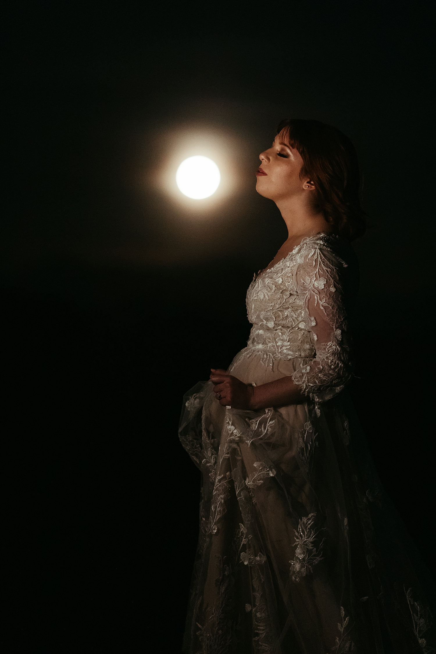 redhead bride closes eyes under night sky for full moon bridal session