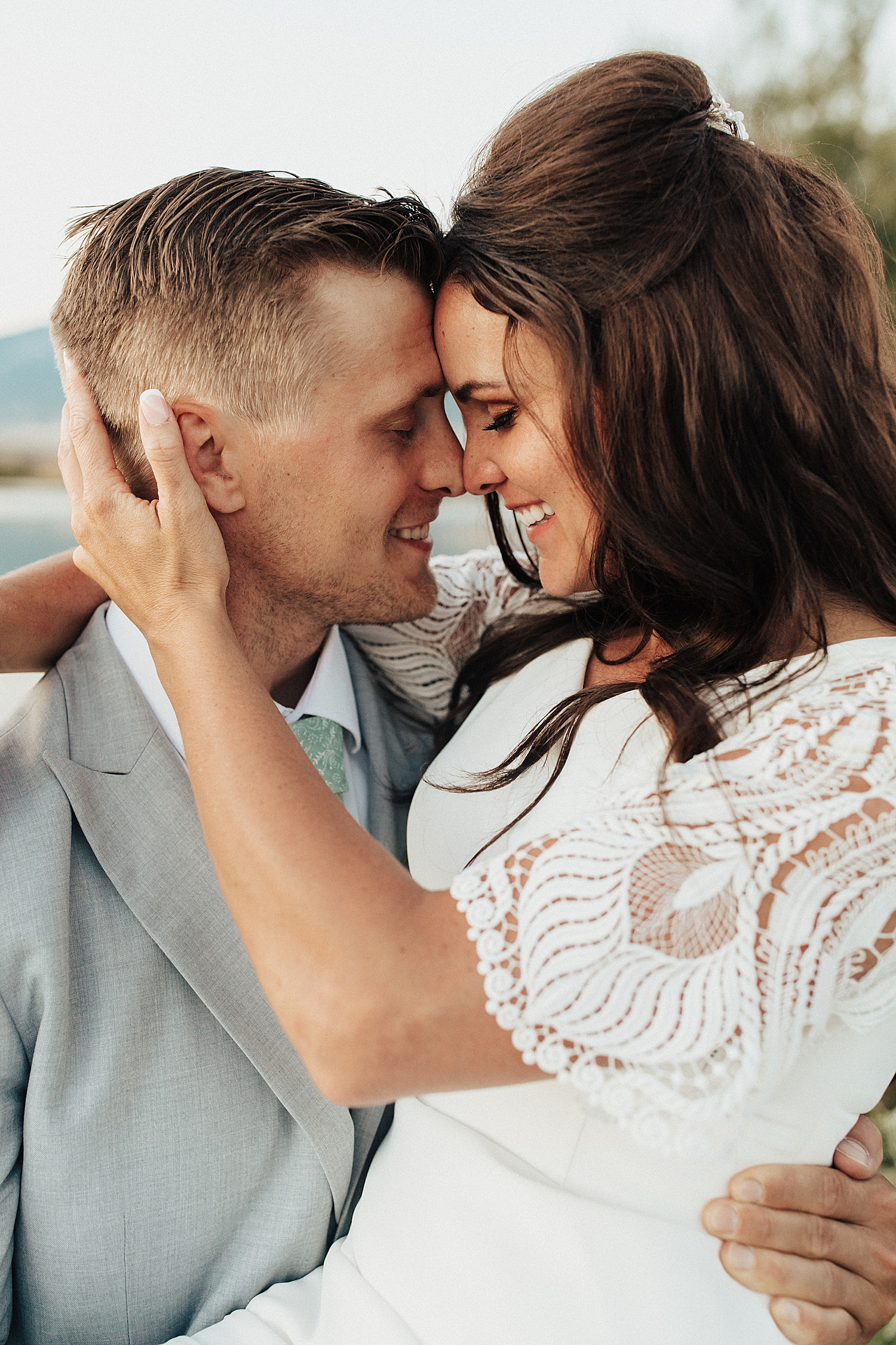 husband and wife snuggle close for bridals at bountiful pond