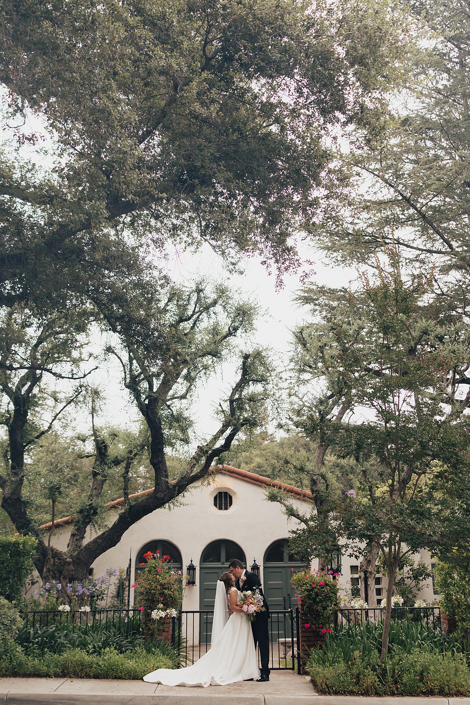 husband and wife share a kiss outside California venue by Nicole Aston Photography