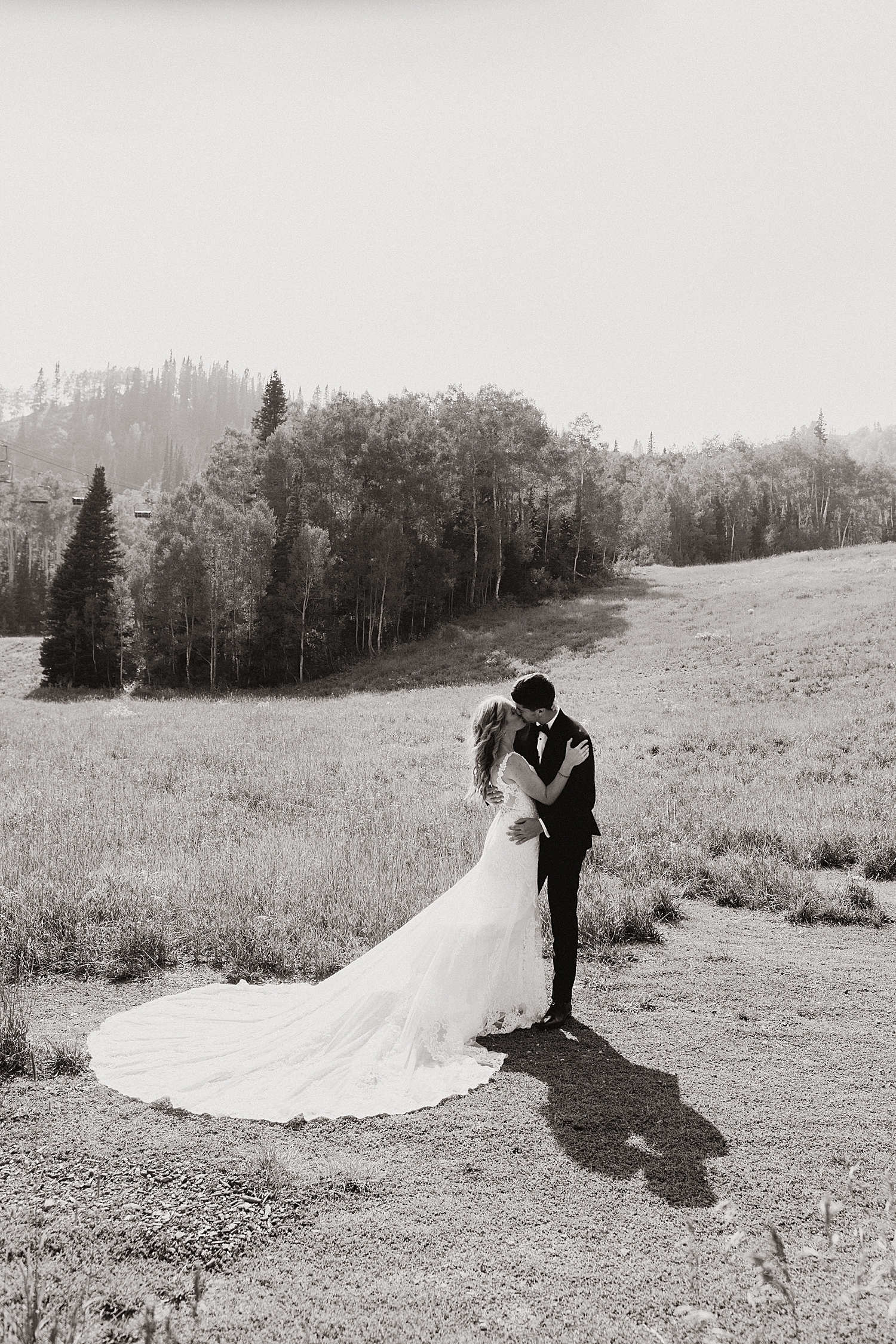 newlyweds kiss in mountain field by Nicole Aston Photography