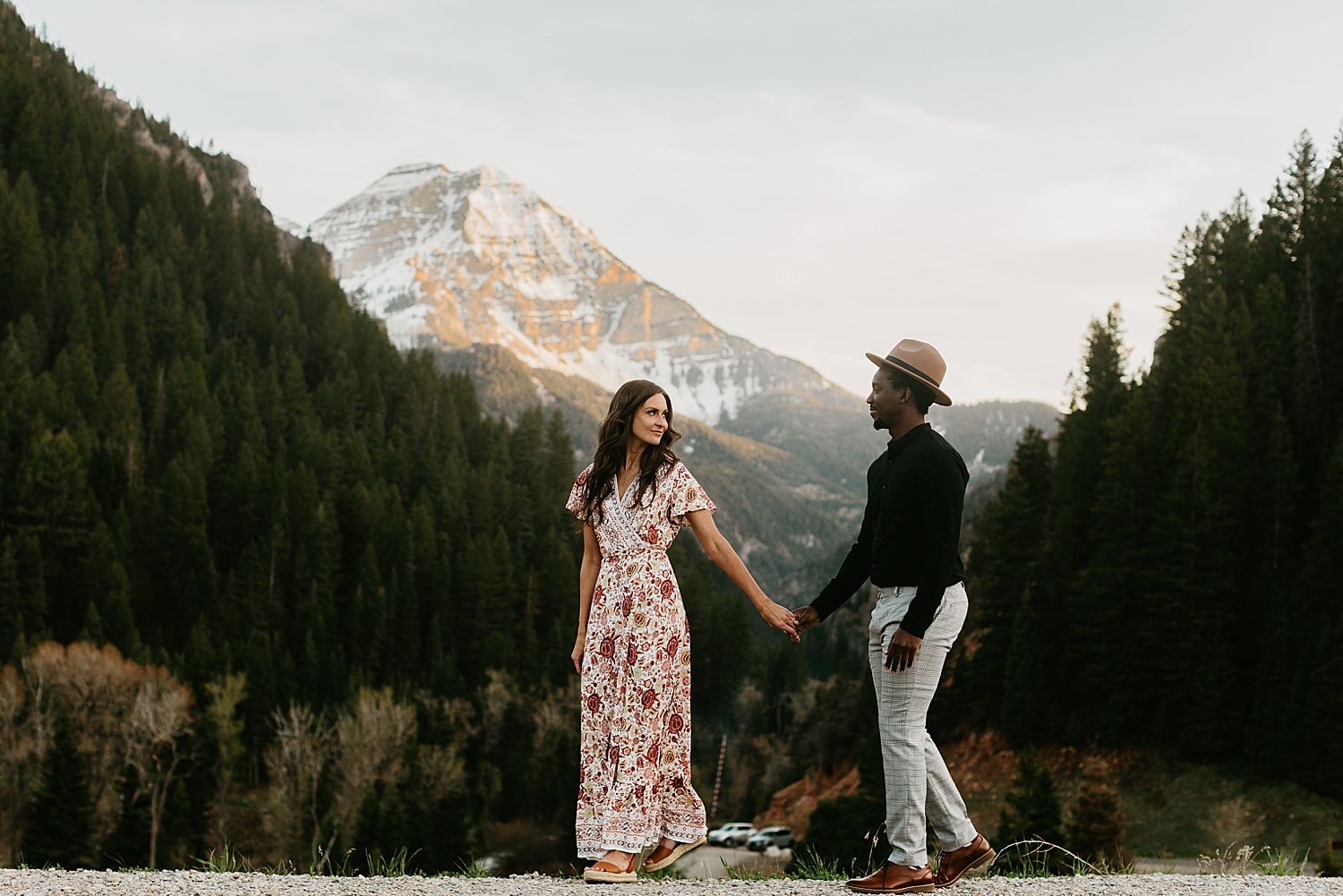 couple walks hand in hand down mountain path by destination wedding photographer