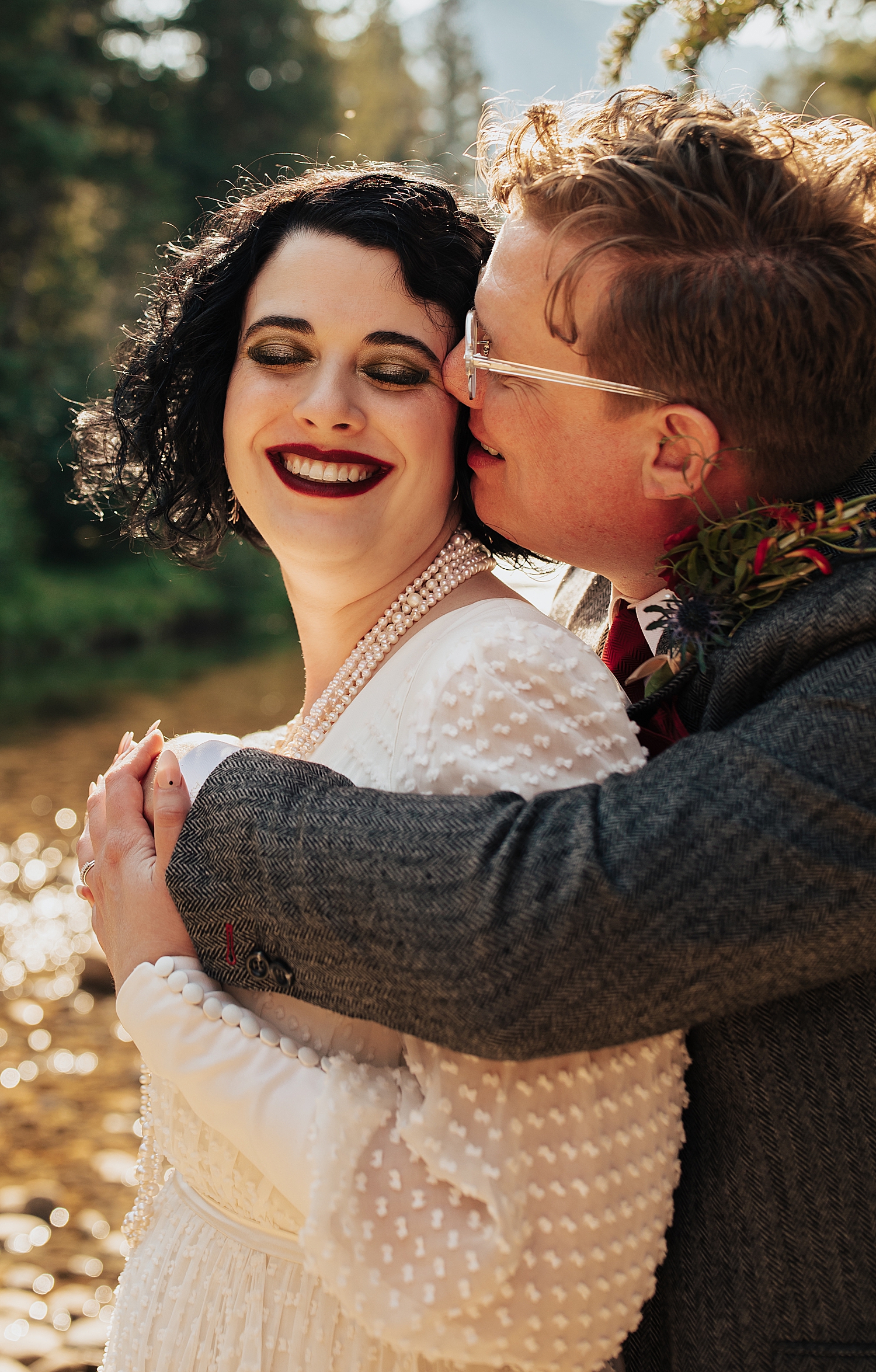 groom leans in to kiss his bride's cheek by Nicole Aston Photography