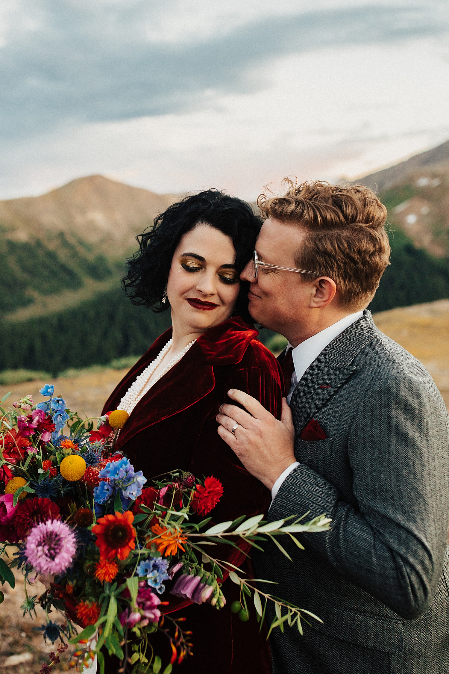 man and woman snuggle closely with picturesque views behind them for Rocky Mountain National Park Elopement