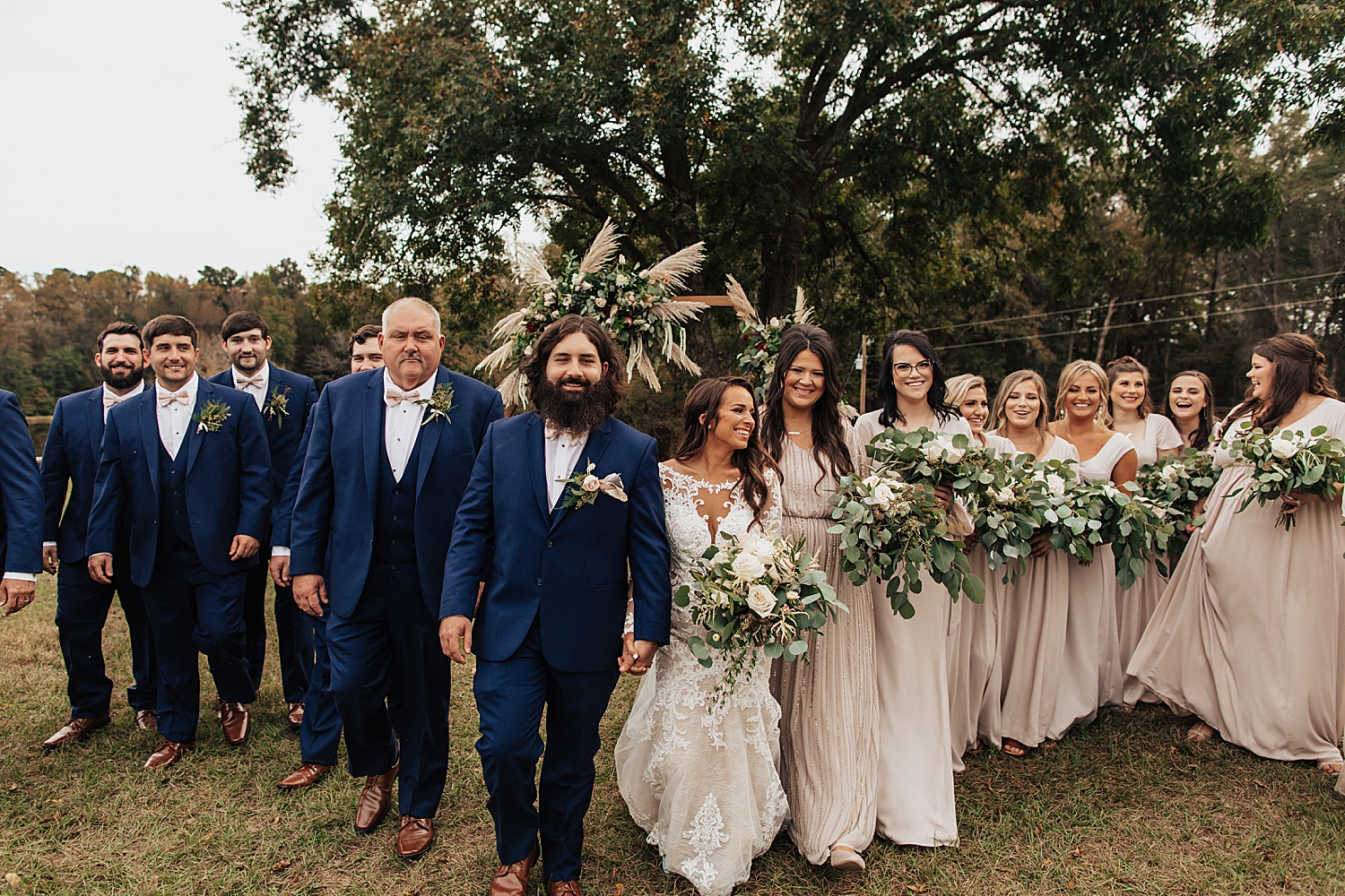 bride and groom walk with their full bridal party by destination elopement photographer
