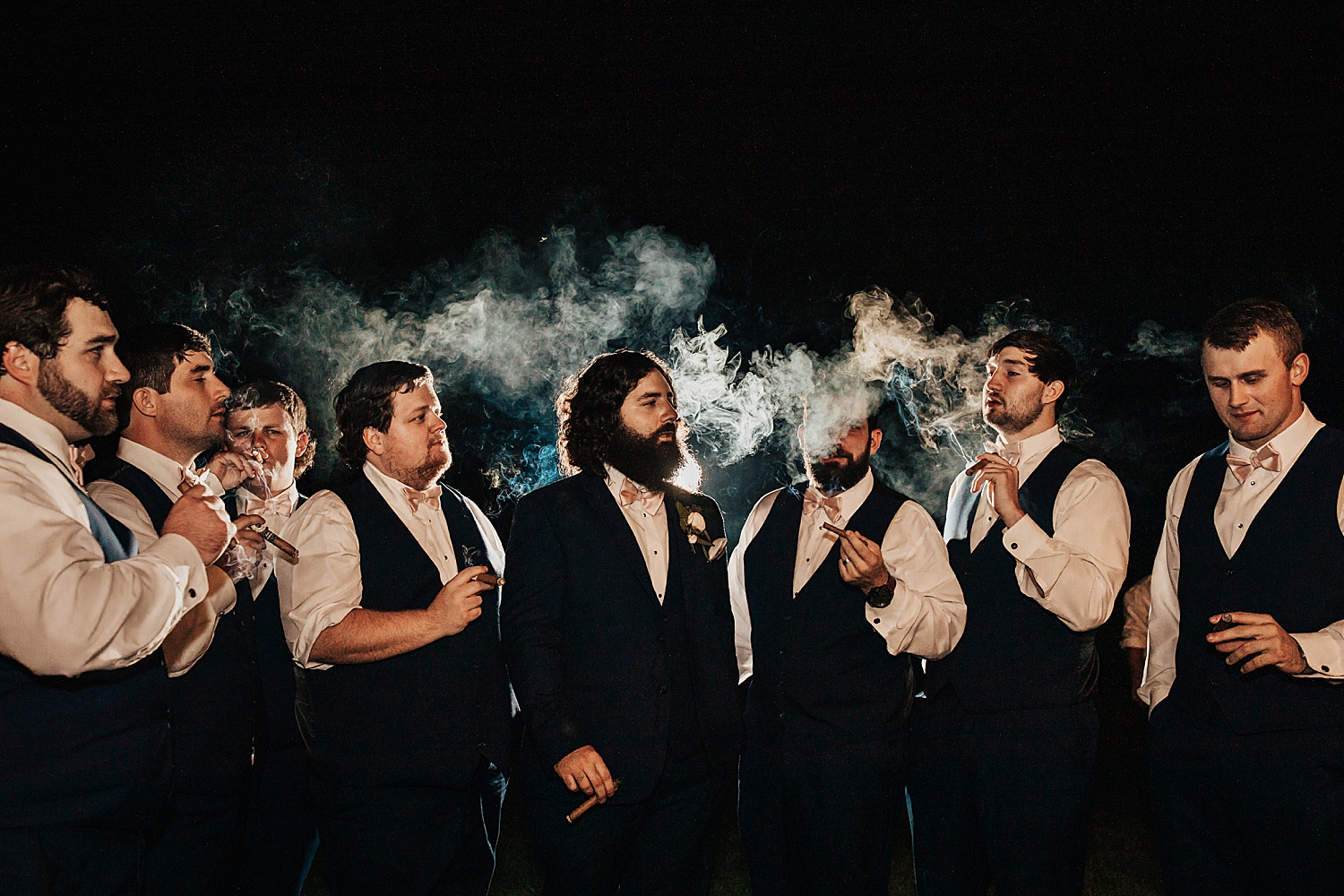 groom and friends smoke cigars after dark by destination elopement photographer