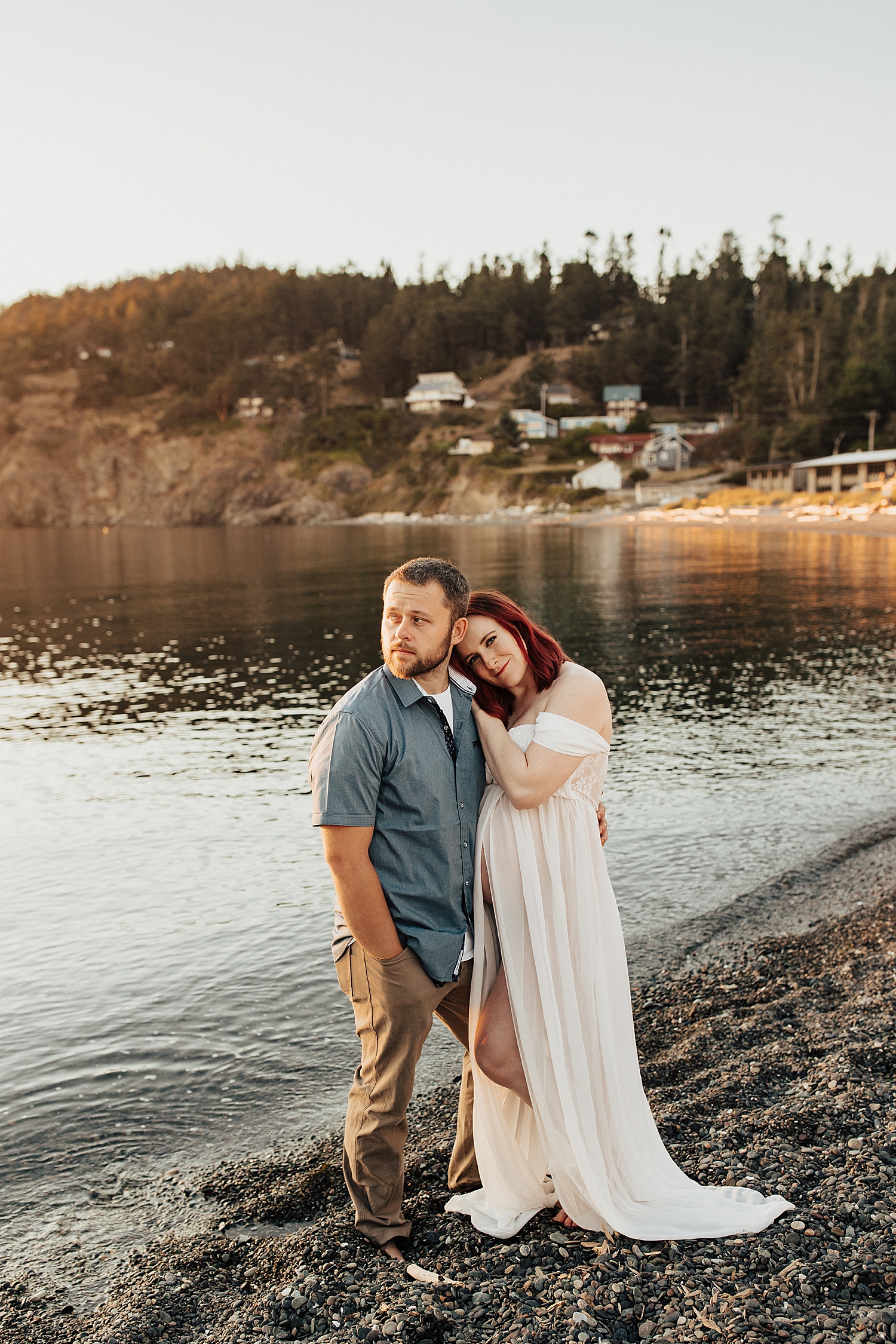 expecting couple stand on shoreline in nice clothing at Rosario Beach